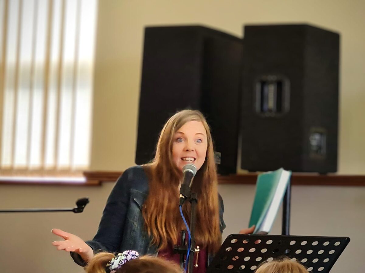 Patti Parks speaking into a microphone at a church gathering